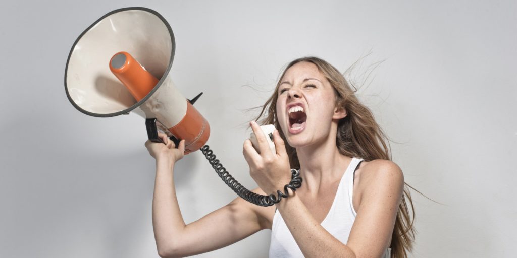 Young girl yelling into a megaphone.