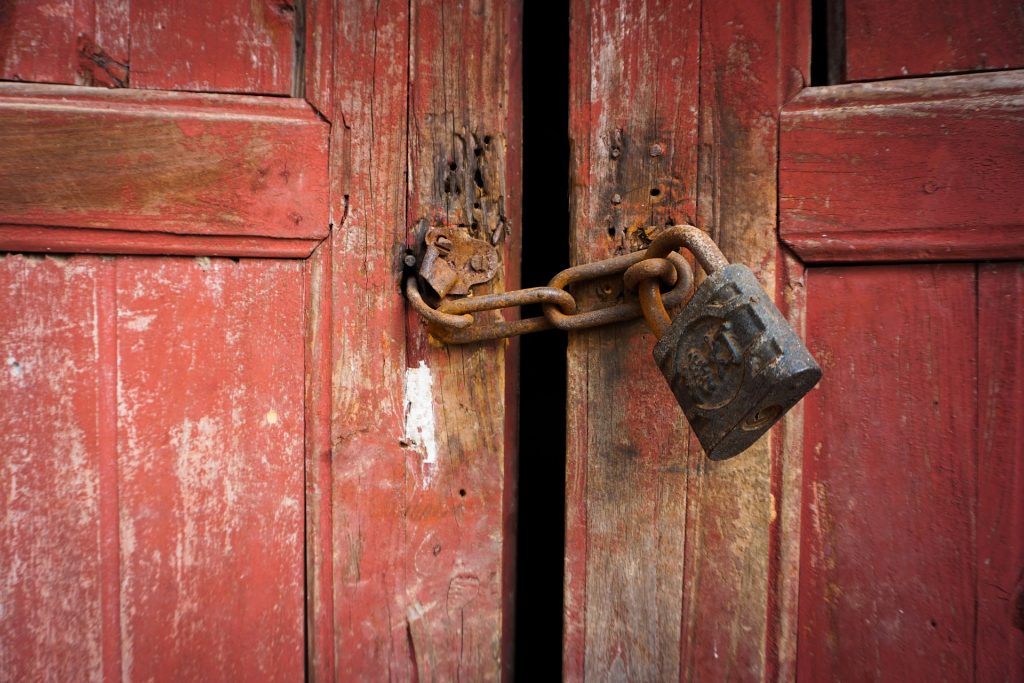 Padlock securing a large door.